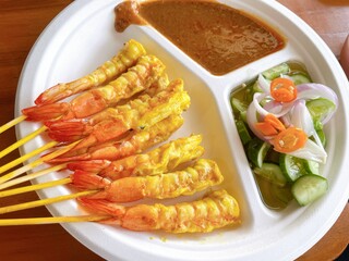  Succulent grilled shrimp skewers served with creamy peanut sauce and pickled cucumber. A fusion twist on a Thai classic.
