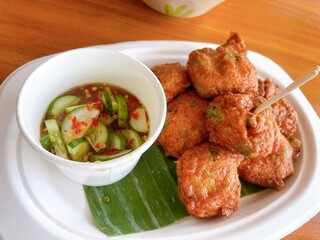 Crispy Thai fish cakes served with sweet and sour dipping sauce and pickled cucumber. A popular Thai appetizer bursting with herbs and spices.