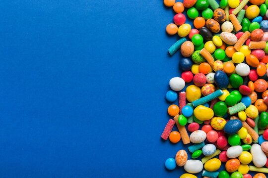 Mixed collection of colorful candy, on colored background. Flat lay, top view. frame of colorful chocolate coated candy