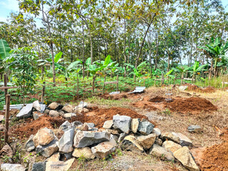 View of the initial construction of a building before it was erected. Builders. Installing river stones. Making house foundations. Indonesia.
