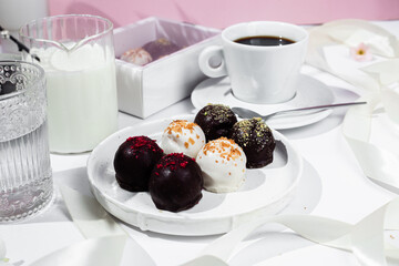 Handmade round chocolate candies on a white plate. Chocolates without sugar. Healthy dessert