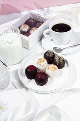 Handmade round chocolate candies on a white plate. Chocolates without sugar. Healthy dessert