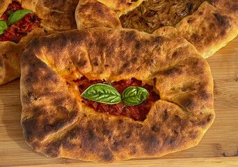 Su Mustazzeddu Typical Sardinian flatbread filled with tomato, onion, and fresh basil leaves