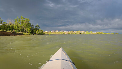 paddling under stormy sky - POV view from paddling kayak or canoe on Boedecker Reservoir in Loveland, Colorado