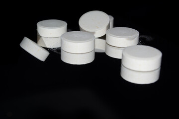 white pills on black background. Pile of white round pills png isolated on transparent background