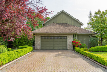 Garage door in luxury house with trees and nice landscape in Spring in Vancouver, Canada, North...