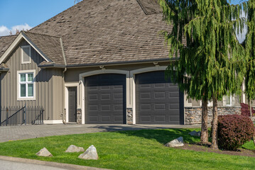 Garage door in luxury house with trees and nice landscape in Spring in Vancouver, Canada, North...