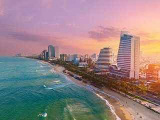 Obraz premium Sunset over Da nang beach skyline with modern architecture and vibrant sky, Vietnam travel