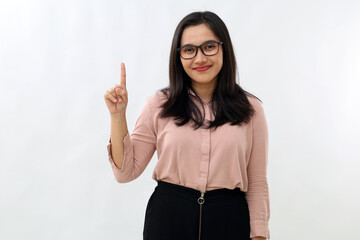 Young Asian woman standing smiling looking at camera, raising hand and showing one finger...