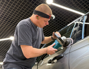 Car detailing series: Polishing grey car close-up. The process of polishing the car body in...