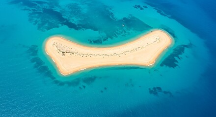 Obraz premium An aerial view of a remote, sandy island surrounded by crystal-clear turquoise waters. 