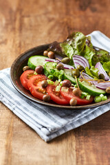 Salad with Olives, Tomatoes and Cucumber on wooden Background. Healthy Snack Idea. Close up.	