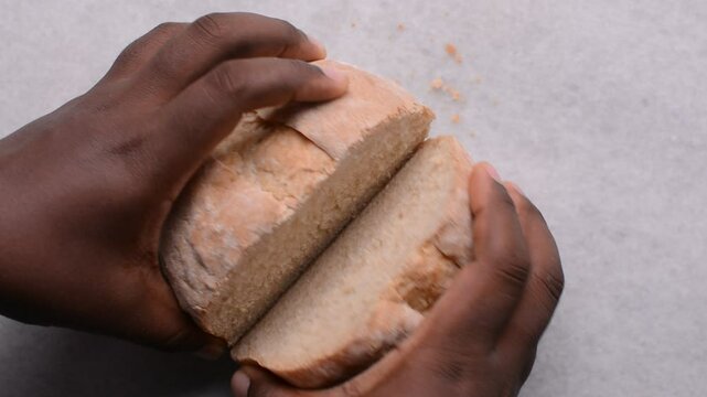 Overhead view of sliced homemade artisan bread on marble countertop, top view of cross-section of sourdough artisan bread on white background