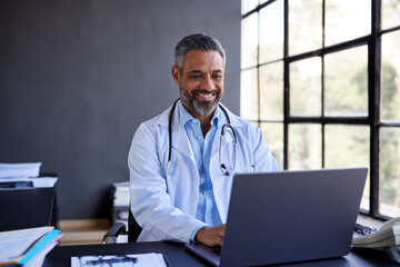 Mixed race doctor working on laptop at office