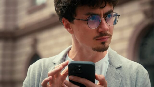 Pensive traveler tourist confused ethnic Hispanic man using mobile phone map navigation searching address navigator application online lost in city smartphone location looking around guy male outdoors