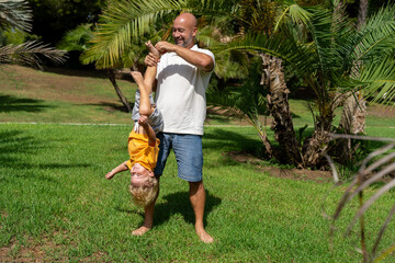 funny father playing with baby feet. . laughter therapy. father tickles his son's legs