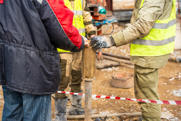 Man cutting and cleaning soil sample for laboratory analysis. Preparation of core material for geotechnical testing and scientific evaluatio