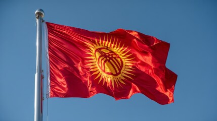 Kyrgyzstan celebrates independence day with the national flag waving proudly against a clear blue sky