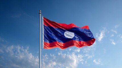 Flag of Laos flying high in celebration of independence day against a clear blue sky