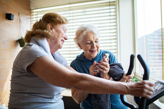 Senior lesbian couple exercising together at home and cheering each other on - Powered by Adobe
