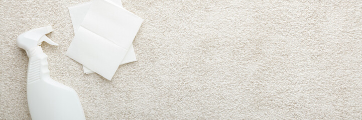 White spray bottle and dry paper napkins for beige soft home carpet cleaning. Wide banner. Closeup. Empty place for text. Top down view.