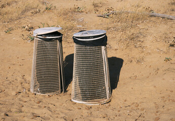 two metal garbage bins on the beach