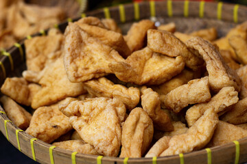 Crispy fried tofu pieces in a bamboo basket. Traditional Asian food, golden brown and delicious. Popular as a snack or side dish in many Southeast Asian cuisines.