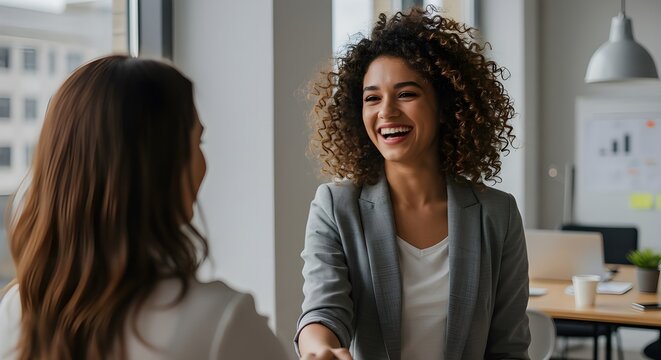 Un apret&oacute;n de manos entre una empresaria o gerente de recursos humanos feliz, segura y entusiasmada y una colega, socia o empleada. Un acuerdo, trato o reuni&oacute;n con un compa&ntilde;ero de trabajo en la sala d