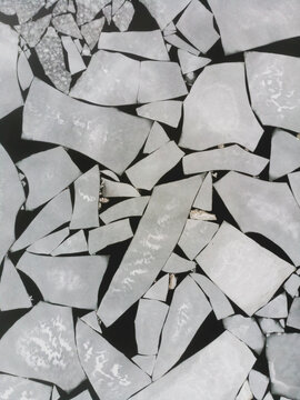 Abstract aerial shot of broken sea ice floating in dark water, resembling pieces of a puzzle. A striking visual of winter's geometric beauty.