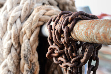 Rusty chain and a mooring rope are resting at the offshore support vessel rail
