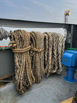 The mooring lines are carefully stored on the main deck on board of the offshore support vessel. Mooring lines are used to secure and keep the ship alongside the berth in port