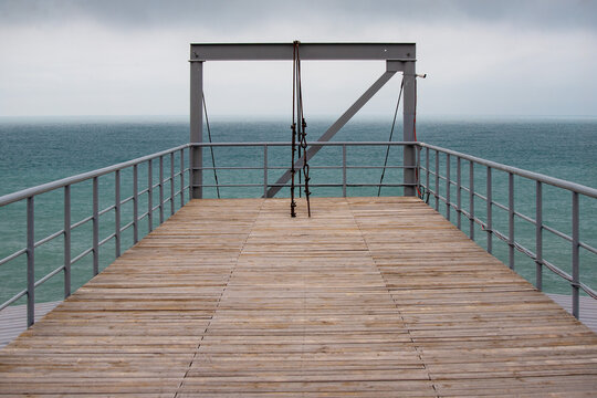 A pier with a wooden deck and a railing