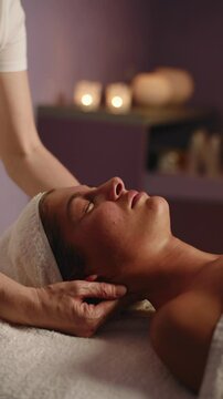 Young Woman Receiving Neck and Head Massage in Spa &ndash; Eyes Closed, Surrounded by Candles and Peaceful Atmosphere &ndash; Deep Relaxation, Self-Care, Wellness Ritual &ndash; Concetto: Relaxation, Spa, Wellness

