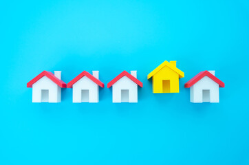 The yellow house stands out from the row. Choosing the best home to buy or rent. Highlights real estate selection, attractive rental or purchase options, and the search for ideal living conditions.