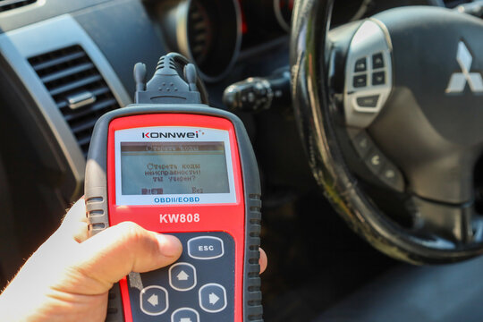 Urich, Ukraine, - 08 June 2024: In the foreground is a diagnostic device in hand, its screen offering to clear car fault codes, creating a focus on repair technologies.