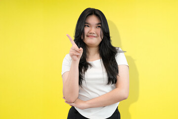 young asian woman thinking and giving idea in yellow studio background