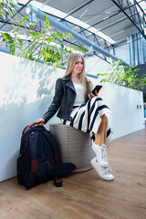 Independent woman in bright indoor space with plant shadows on the wall travel or coworking concept.