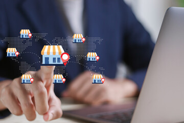 Fototapeta na wymiar Franchise business store shop concept. Investment expansion with location world map and open new branch shop. Businessman touching franchise icon on virtual screen.