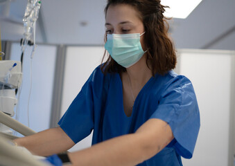 Nurse wearing surgical mask working in hospital room
