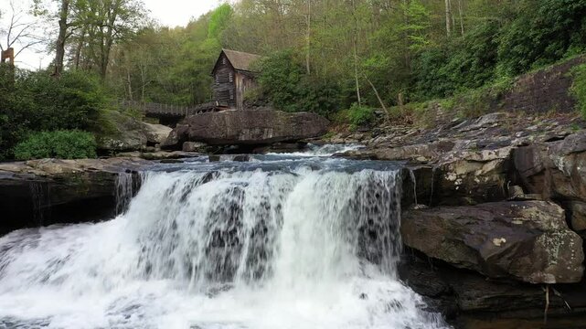 Explore Babcock State Park in West Virginia, featuring a historic grist mill and a beautiful waterfall surrounded by vibrant spring foliage and nature.
