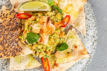 Gourmet shrimp guacamole served with crispy tortilla chips and fresh herbs