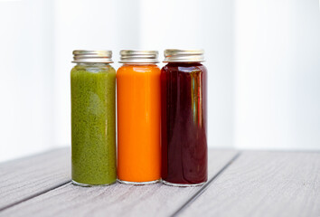 Three colorful bottles of fresh cold-pressed juice on white background – clean minimal stock photo for healthy lifestyle, detox drinks, wellness brand, organic beverage, and food blog use. Wellness