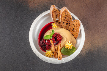 Elegant liver pate with cherry compote, toasted bread, and decorative butter swirls.