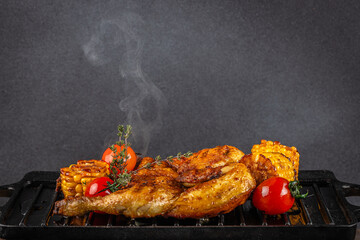 Hot grilled chicken with roasted corn, cherry tomatoes, and fresh thyme on a smoky grill
