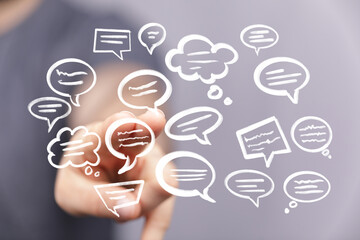 Hand interacts with floating speech bubbles, concept for communication, social media, or online...