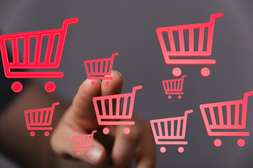 Person interacts with digital shopping carts, symbolizing online shopping and e-commerce.