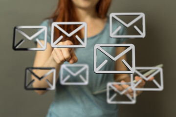 Close-up of a woman interacting with email icons on a touchscreen device.
