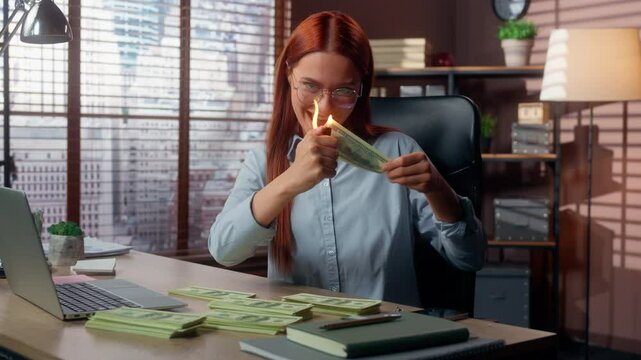 Caucasian happy business woman businesswoman burning money cash with fire in office female girl entrepreneur employer rich crazy funny burn dollars joy holding banknote in flame financial overspending