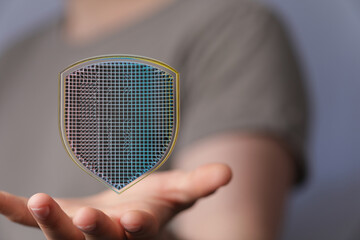 Abstract digital shield graphic on hand, representing data security and online protection.