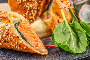 Baked salmon en croute with spinach, sesame crust, mashed potatoes, and fresh greens.